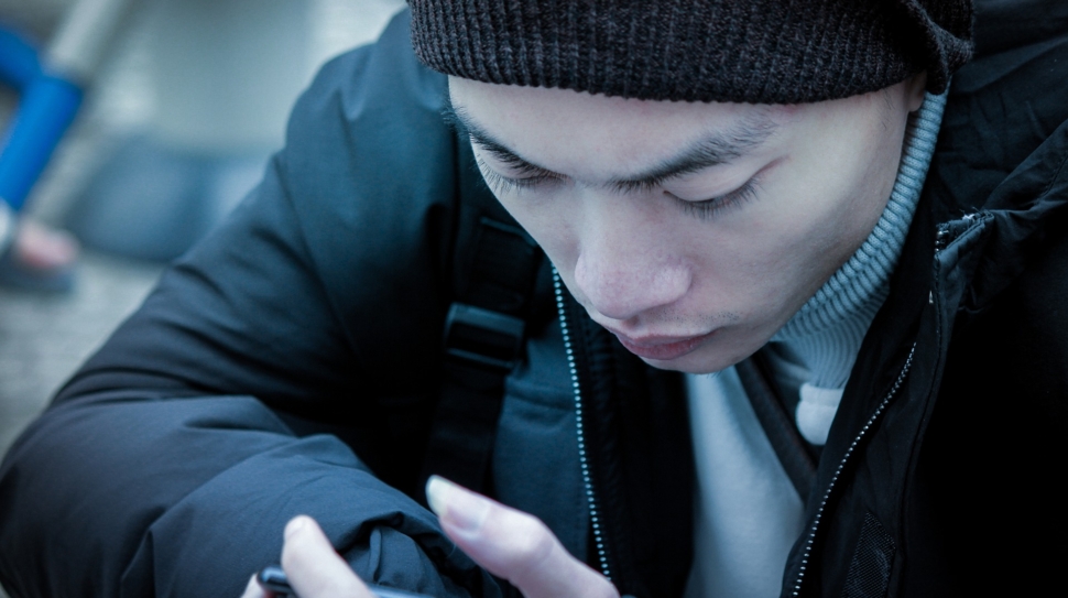 A man looks intently at his smartphone.