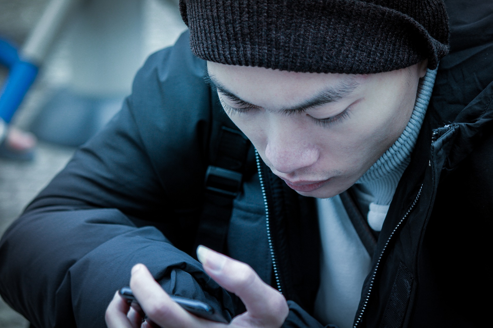 A man looks intently at his smartphone.